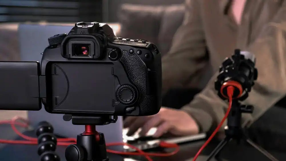 Black DSLR camera with microphone.