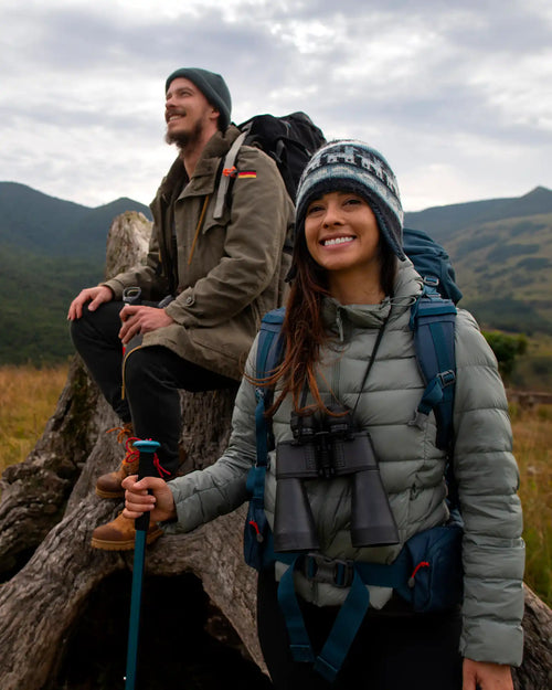 Two smiling hikers in winter clothing and gear.